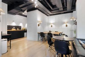 una sala da pranzo con tavoli e sedie e una cucina di Hounslow Central Studio Aparments a Hounslow