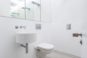 un bagno bianco con un water e un lavandino di Hounslow Central Studio Aparments a Hounslow