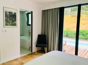 a bedroom with a bed and a tub and a chair at Villa Vagues de Vie - 4 Étoiles in Labenne +26 photos