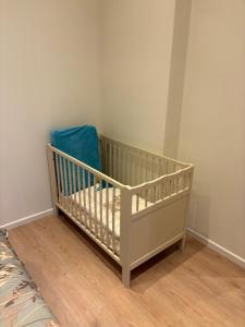 a baby crib in a corner of a room at C-side in Blankenberge +5 photos