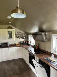 eine Küche mit weißen Schränken und einem Herd mit Backofen in der Unterkunft Skye Cottage - Vegan and Eco in Bernisdale