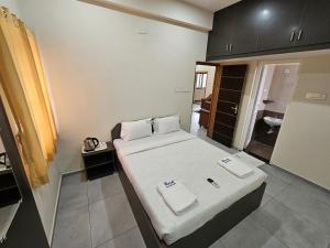 a small room with a bed with towels on it at Royal Service apartment - KK Nagar Madurai in Madurai