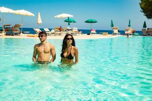 a man and woman in the water at a resort at Club Hotel Marina Seada Beach in Budoni