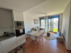 a kitchen and living room with a table and a couch at La Isla in Isla de Arosa