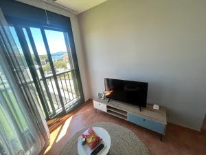 a living room with a tv and a large window at La Isla in Isla de Arosa