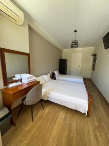 a hotel room with a bed and a desk and a bed at Paradosi Rooms in Igoumenitsa