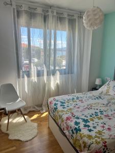 a bedroom with a bed and a chair and a window at La Isla in Isla de Arosa