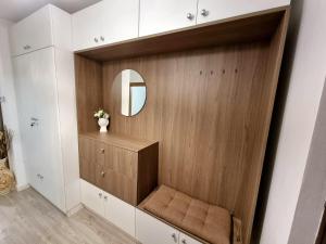 a dressing room with a mirror and a wooden cabinet at Ra Apartment in Oradea
