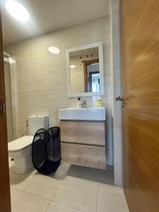 a bathroom with a sink and a toilet and a mirror at La Isla in Isla de Arosa +8 photos