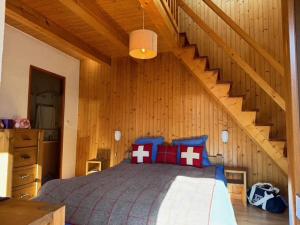 una camera da letto con un letto in una casa di legno di Maison de village aux Allues proche commerces et télécabine pour 6 pers. - FR-1-411-987 a Les Allues