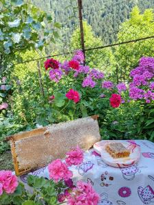 a table with a plate of cake and pink flowers at Napertskala Guesthouse in Utsera