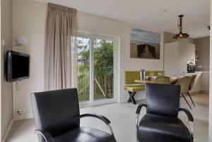 a living room with chairs and a table and a window at See and Stay Oostkapelle - Dog-Friendly Holiday Home in Oostkapelle