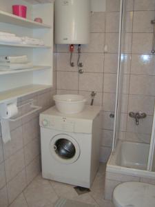 een badkamer met een wasmachine en een douche bij Blue Holidays Apartment in Šibenik