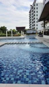 a swimming pool with blue and white tiles on the ground at Royal Oceancrest Panglao Seaview in Dauis +6 photos