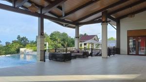 an outdoor patio with a pool and a pavilion at Royal Oceancrest Panglao Seaview in Dauis