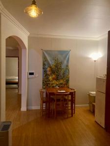 a dining room with a table and a painting on the wall at A spacious, cosy, independent house in Pohang