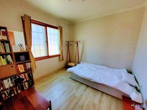 a bedroom with a bed and a book shelf at A spacious, cosy, independent house in Pohang