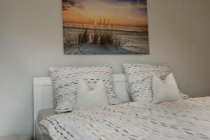 a bed with pillows and a picture of a beach at Ostseeperle in Boltenhagen