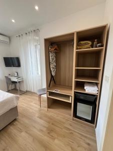 a bedroom with a closet with a desk and a bed at Soukki Town Centre Suites 1 in Split