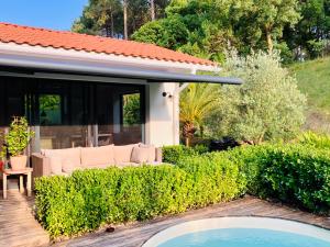 a garden with a couch and a house at Villa Vagues de Vie - 4 Étoiles in Labenne