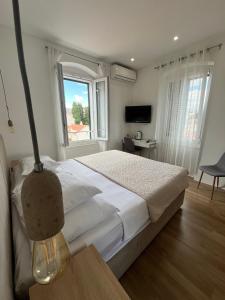 a bedroom with a large bed and a window at Soukki Town Centre Suites 1 in Split