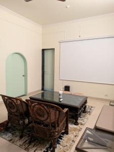 a room with a table and chairs and a large screen at Sanctuary by Nagarik Commune in Pune +49 photos
