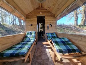 zwei Bänke auf der Rückseite eines Hauses mit Fenstern in der Unterkunft Weiherhof Cottage in Radolfzell am Bodensee
