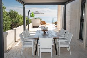 a wooden table and chairs on a patio at Villa Stone house in Novalja