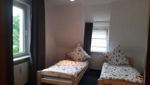 a small room with two beds and a window at Ferienwohnung Niesner Mitten in Sterkrade Oberhausen nah am Westfield Centro in Oberhausen