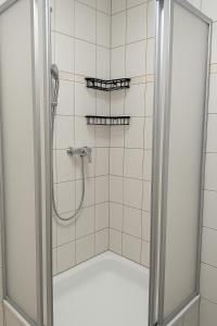a shower with a glass door in a bathroom at Pension Sonne in Baden-Baden
