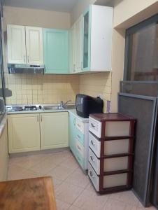 cocina con armarios blancos, fregadero y encimera en E&B Cosy Apartment 4, en Tirana