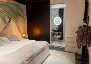 a bedroom with a bed with a large painting on the wall at Uniikki keskustahuoneisto pihaterassilla, bm Garden Apartments no1, free parking in Lahti