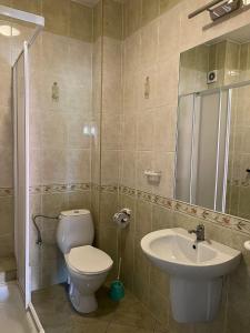 a bathroom with a toilet and a sink at Bursztynowy Brzeg in Sarbinowo +53 photos