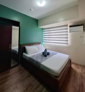 Un dormitorio con una cama en una habitación con ventana. en 2-BR Condo at the heart of the city, en Davao City