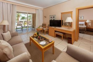 a living room with a couch and a desk at JAZ Makadi Star & Spa - Adults Only in Hurghada +69 photos