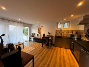 a kitchen and living room with wooden floors and a table at Bormes les Mimosas in Bormes-les-Mimosas