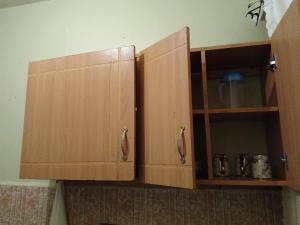 two wooden cabinets with their doors open in a kitchen at Naivasha Lake Vista Guesthouse in Lotus Island +35 photos