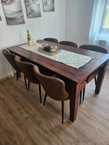 a wooden table with chairs and a bottle of wine on it at Ferienhaus Stefan in Kall