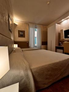 a hotel room with a large bed and a window at Hotel Alinari in Florence