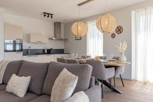 a living room and kitchen with a couch and a table at Appartement Havenzicht 13A Kortgene in Kortgene