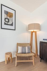 a living room with a chair and a lamp at Appartement Havenzicht 13A Kortgene in Kortgene