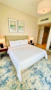 a large white bed in a room with a rug at شقه فاخره في فندق العنوان ثلاث غرف نوم اطلاله علي البحر مباشره in Fujairah