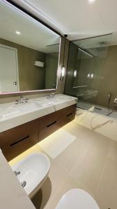 a bathroom with two sinks and a large mirror at شقه فاخره في فندق العنوان ثلاث غرف نوم اطلاله علي البحر مباشره in Fujairah