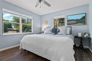 a bedroom with a bed and two windows at Walnut House - Close to Downtown Fire Pit in Fredericksburg