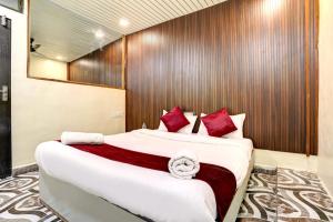 a bedroom with a large bed with red pillows at Hotel Akasa View in Mumbai