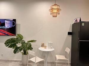 a dining room with a table and a black refrigerator at Vinhomes Grand Park Homestay-The Beverly Hills in Long Bình