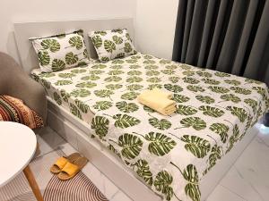 a bed with a green and white comforter and pillows at Vinhomes Grand Park Homestay-The Beverly Hills in Long Bình