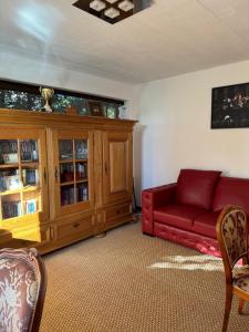 a living room with a red couch and a wooden cabinet at Luxury Villa in Cluj-Napoca