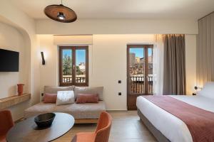 a hotel room with a bed and a couch at Zoera Suites by Ethos in Chania