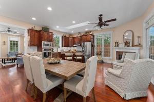 フレデリックスバーグにあるCharmed Haus - Hot tub & Pool Tableの木製のテーブルと椅子のあるキッチンとリビングルーム